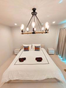 a bedroom with a large bed with a chandelier at The Nakara Town in Ban Rangeng