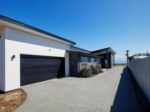 a driveway of a house with a garage at The Kaikoura Bach Retreat in Kaikoura