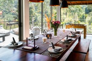 a wooden table with plates and glasses on it at Bellaxy Ceylon in Ella