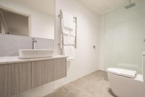 Baño blanco con lavabo y aseo en The Lighthouse Hotel en Ulverstone