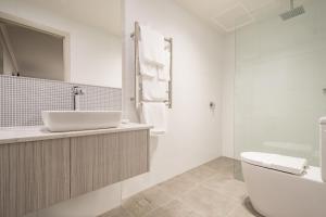 a bathroom with a toilet, tub, sink and shower at The Lighthouse Hotel in Ulverstone