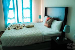 ein Schlafzimmer mit einem großen Bett mit weißer Bettwäsche und Kissen in der Unterkunft Imvomvo Country Lodge in Mount Ayliff
