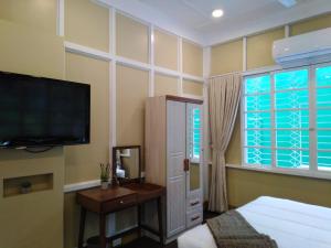 - une chambre avec une télévision à écran plat et un lit dans l'établissement R Bed and Breakfast, à Baguio