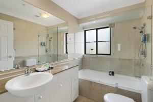 a bathroom with a sink and a toilet and a tub at YEHS Hotel Sydney Harbour Suites in Sydney