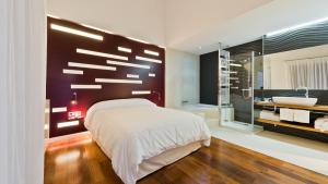 a bedroom with a large white bed and a bathroom at Hotel Las Casas de Pandreula in Berlanga de Duero