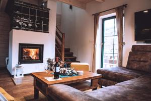 a living room with a table and a fireplace at Chata BlueBerry in Belá
