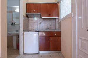 a kitchen with a white refrigerator and a sink at House Aggeliki in Kalamitsi