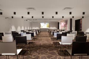 Habitación con filas de sillas y pantalla de proyección en OREA Congress Hotel Brno, en Brno