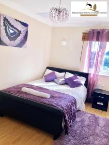 a bedroom with a bed with purple pillows and a purple rug at 2 Bedroom Apartment at Dagenham , Adonai Serviced Accommodation, Free WiFi and Parking in Dagenham