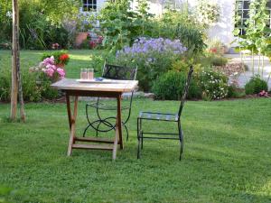 una mesa y dos sillas sentadas en el césped en Les Célestines, en Lavannes