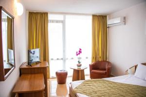 a hotel room with a bed and a chair and a window at Hotel Mures in Saturn