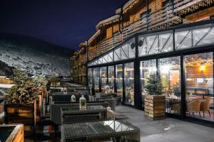 a restaurant with tables and windows at night at Gudauri Hills Apart Hotel in Gudauri