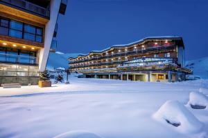 a building covered in snow in front of a building at Gudauri Hills Apart Hotel in Gudauri