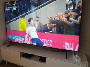 TV de pantalla plana con un partido de fútbol. en Y stay en Daegu