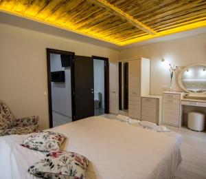 a bedroom with a large white bed and a mirror at Archontiko Liamas in Stavros