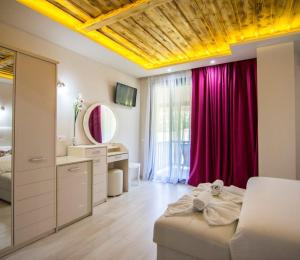 a bedroom with a bed and a vanity and a mirror at Archontiko Liamas in Stavros