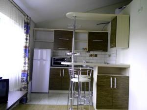 una cucina con sgabello e frigorifero bianco di Studio apartments in center MINI 5/5 a Ivano-Frankivsʼk