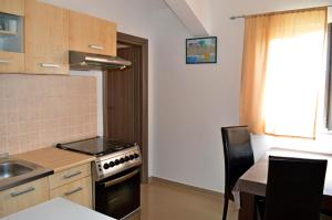 cocina con fogones, fregadero y mesa en Apartments Ante 1306, en Seline