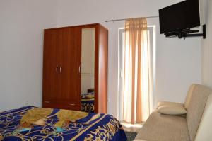 1 dormitorio con 1 cama, armario y TV en Apartments Ante 1306, en Seline