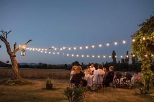 a group of people sitting at a table under lights at La Bastide des Bourguets, Mont Ventoux - Adults Only in Sault-de-Vaucluse