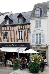 eine Gruppe von Personen, die vor einem Gebäude an Tischen sitzen in der Unterkunft Villa Roma B&B in Amboise