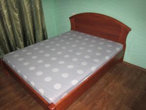 a bed with a wooden bed frame with polka dots at Комфортная 2-комнатная Новопречистенская 1, Три раздельных двуспальных места in Cherkasy