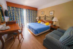 a hotel room with a bed and a couch at Topaz Hotel in St Paul's Bay