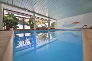 une grande piscine avec une grande piscine dans l'établissement Hotel Christina, à Seefeld in Tirol