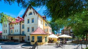 a large yellow and white building with a red roof at Hotel Kryształ in Świeradów-Zdrój