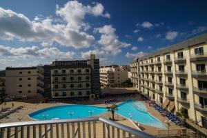 a view of a swimming pool between two buildings at Topaz Hotel in St Paul's Bay