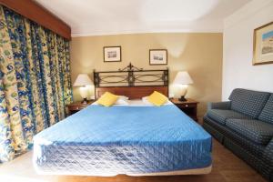 a bedroom with a blue bed and a chair at Topaz Hotel in St Paul's Bay