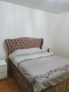 a bed in a white room with a bedspread at Central1 in Pančevo