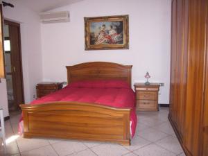 una camera con letto in legno e un dipinto sul muro di Su Barroccu a Riola Sardo