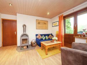 sala de estar con sofá azul y estufa de leña en Apartment in Werratal with terrace, en Großalmerode
