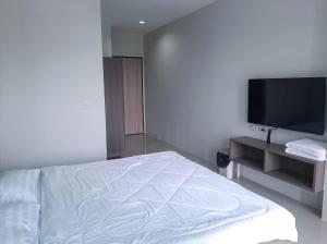 a bedroom with a bed and a flat screen tv at AFP Residence Hotel in Bangkok