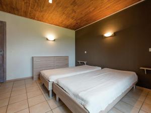 a bedroom with a large bed with a wooden ceiling at Magnificent Villa in Brisy with Sauna Roofed Terrace and BBQ in Brisy