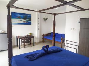 a bedroom with a blue bed and a dining room at Sea Star Bali in Uluwatu