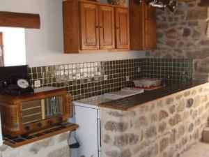 una cocina con armarios de madera y una pared de piedra. en Beautiful holiday home with mountain view, en Sauvain