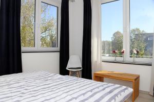 a bedroom with a bed and two large windows at Am Stadtgarten in Simmern