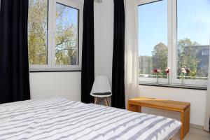 1 dormitorio con 1 cama y 2 ventanas grandes en Am Stadtgarten, en Simmern