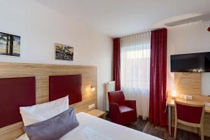 ein Hotelzimmer mit einem Bett und einem Stuhl in der Unterkunft SmartMotel Emden - by Quartier96 GmbH in Emden