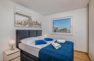a bedroom with a large bed with blue sheets at Apartments Elle Luxury Vantačići in Malinska