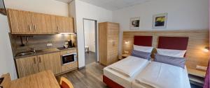 a bedroom with a large bed and a kitchen at SmartMotel Emden - by Quartier96 GmbH in Emden