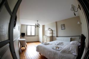 a bedroom with a large white bed and a chair at Villa Roma B&B in Amboise