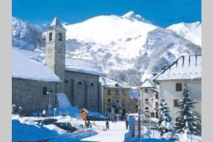 un edificio con una montagna innevata sullo sfondo di VALLOIRE, studio 22m2, tout à pied, remontées mécaniques à 100m a Valloire