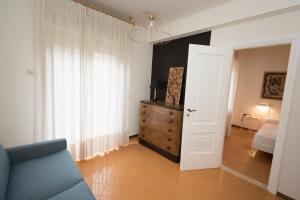 a living room with a blue couch and a bedroom at Mami Sabaudia Hotel in Sabaudia