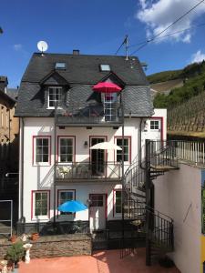a white house with two umbrellas on top of it at Mosel Ferienhaus Reblaus in Zell an der Mosel