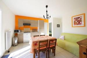 een keuken en eetkamer met een tafel en een bank bij Maison calme avec jardin et parking privés in Marsillargues