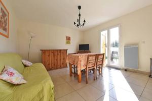 een woonkamer met een tafel en een bank bij Maison calme avec jardin et parking privés in Marsillargues