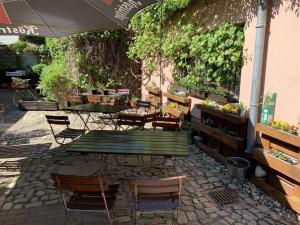 une terrasse avec une table, des chaises et un parasol dans l'établissement Altes Brauhaus, à Weißenfels